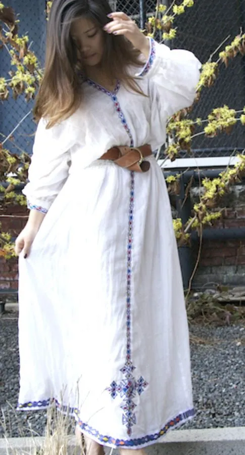 White, long sleeved traditional Ethiopian dress with blue and red cross embroidered motif