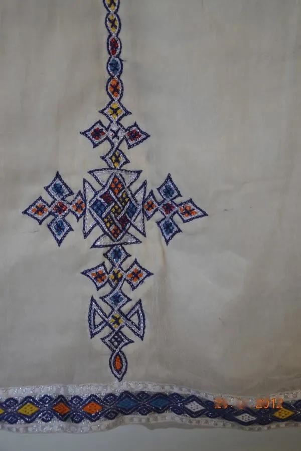 White, long sleeved traditional Ethiopian dress with blue and red cross embroidered motif